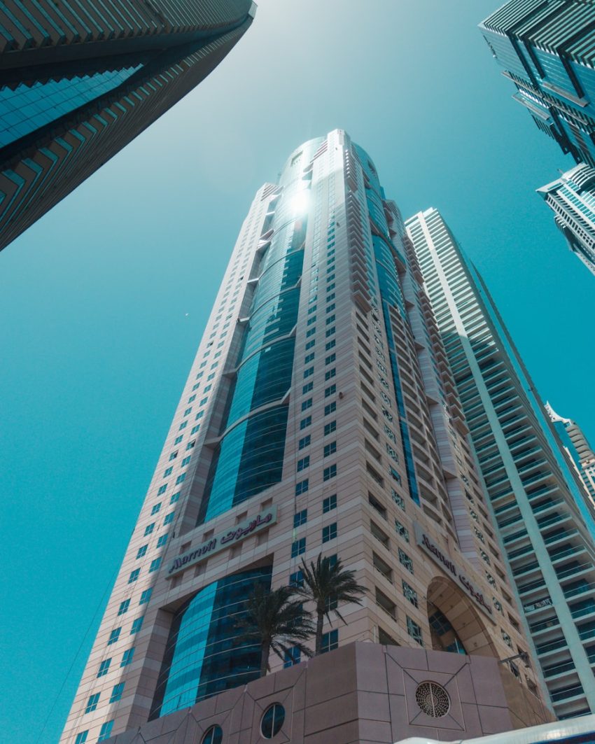 a tall building with palm trees in front of it